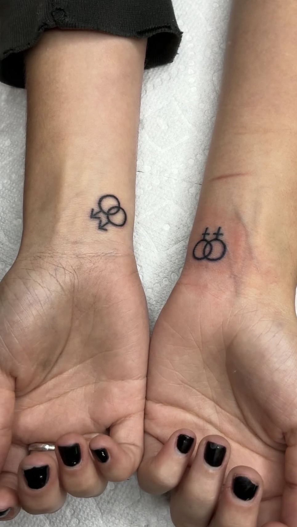 Matching fine line symbol wrist tattoos by Hushtown Tattoos, Jacksonville Florida