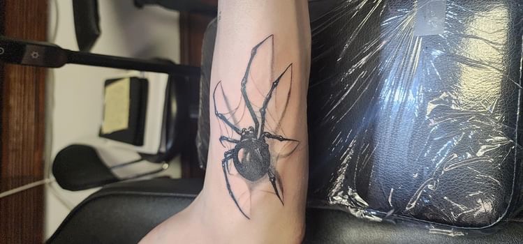 Realistic black widow spider tattoo