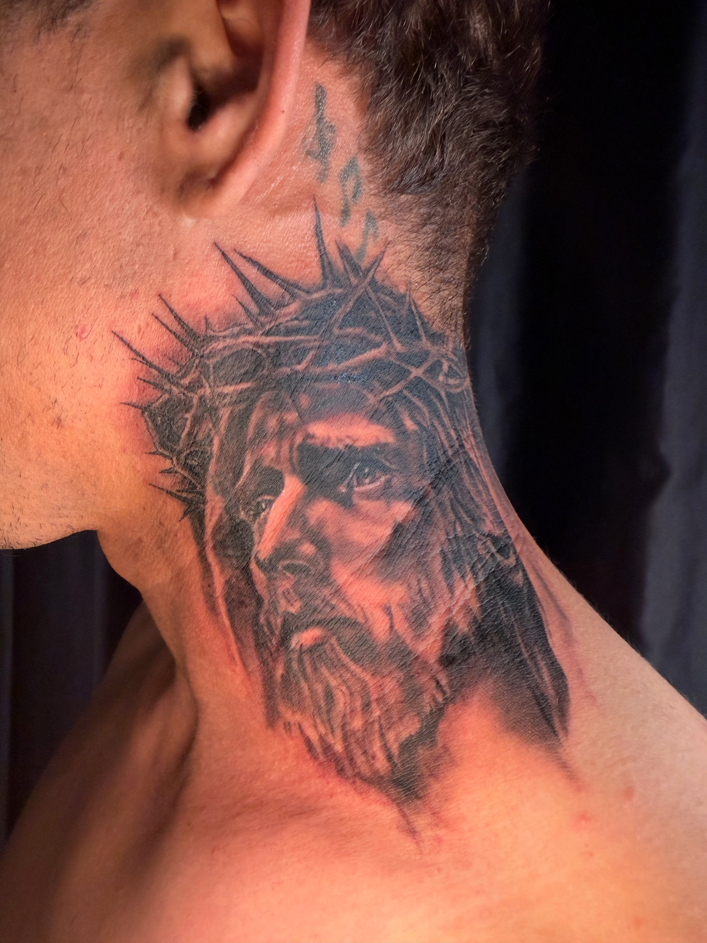 Black and grey Jesus portrait neck tattoo with crown of thorns