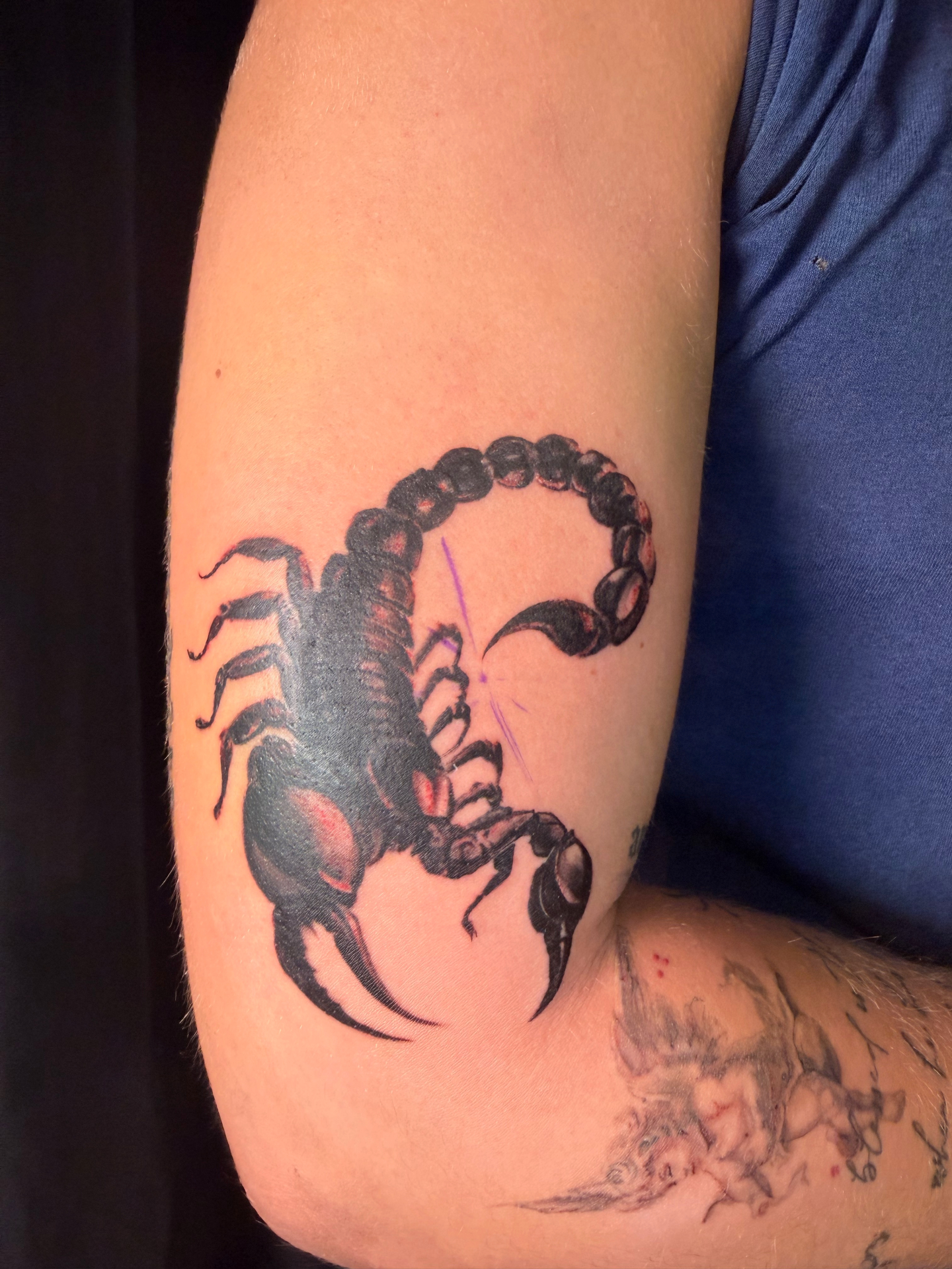 Black and grey scorpion upper arm tattoo
