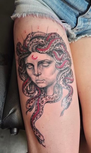 Medusa portrait tattoo with red snakes on thigh