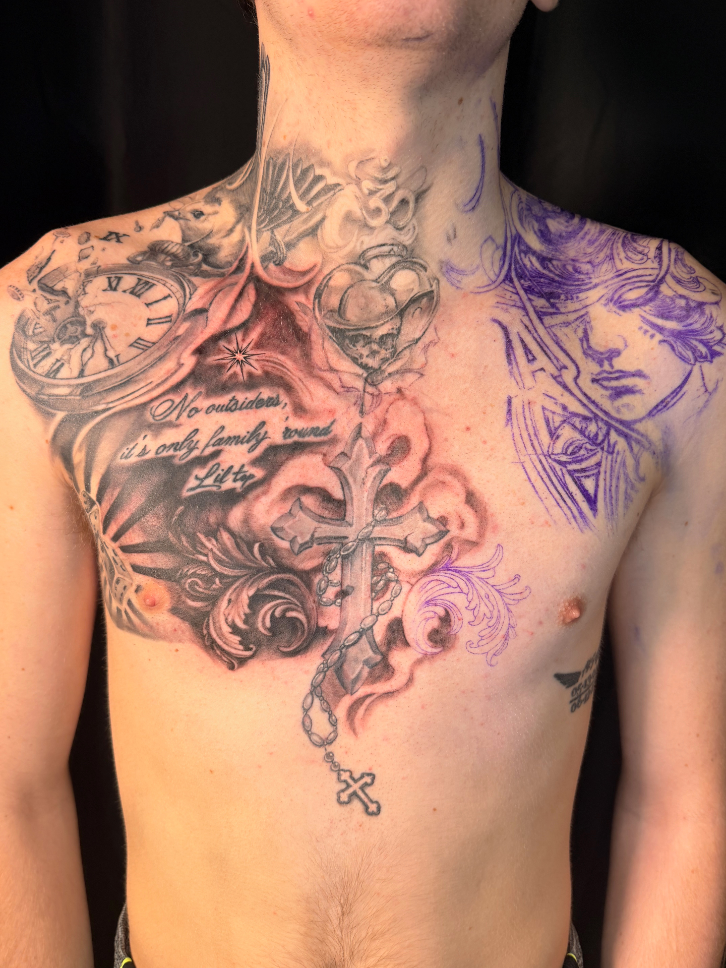 Black and grey chest tattoo with ornate cross, rosary, pocket watch, dove and family script
