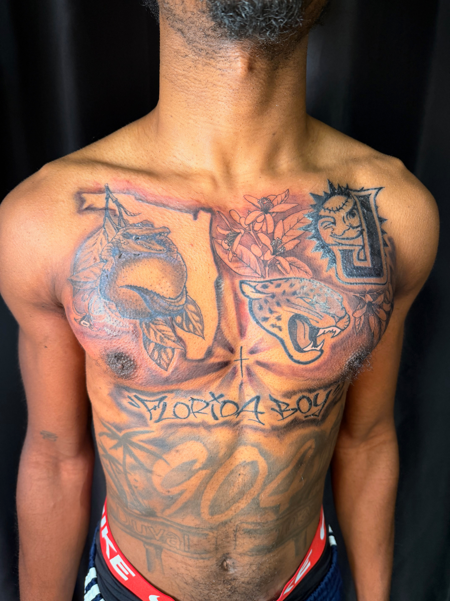 Florida Boy themed chest tattoo with jaguar, orange blossoms, lemon and lettering