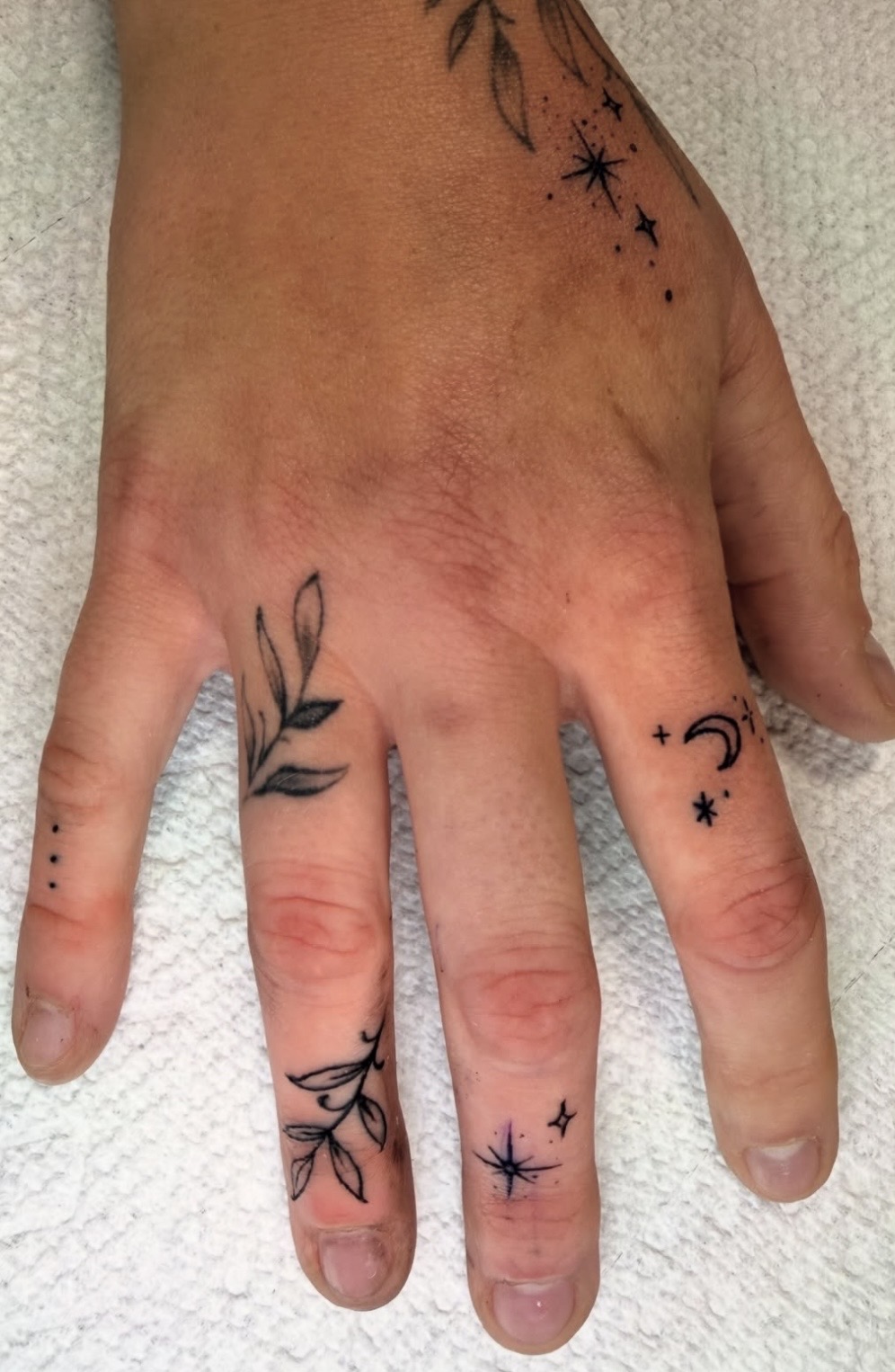 Fine line botanical and celestial hand tattoos