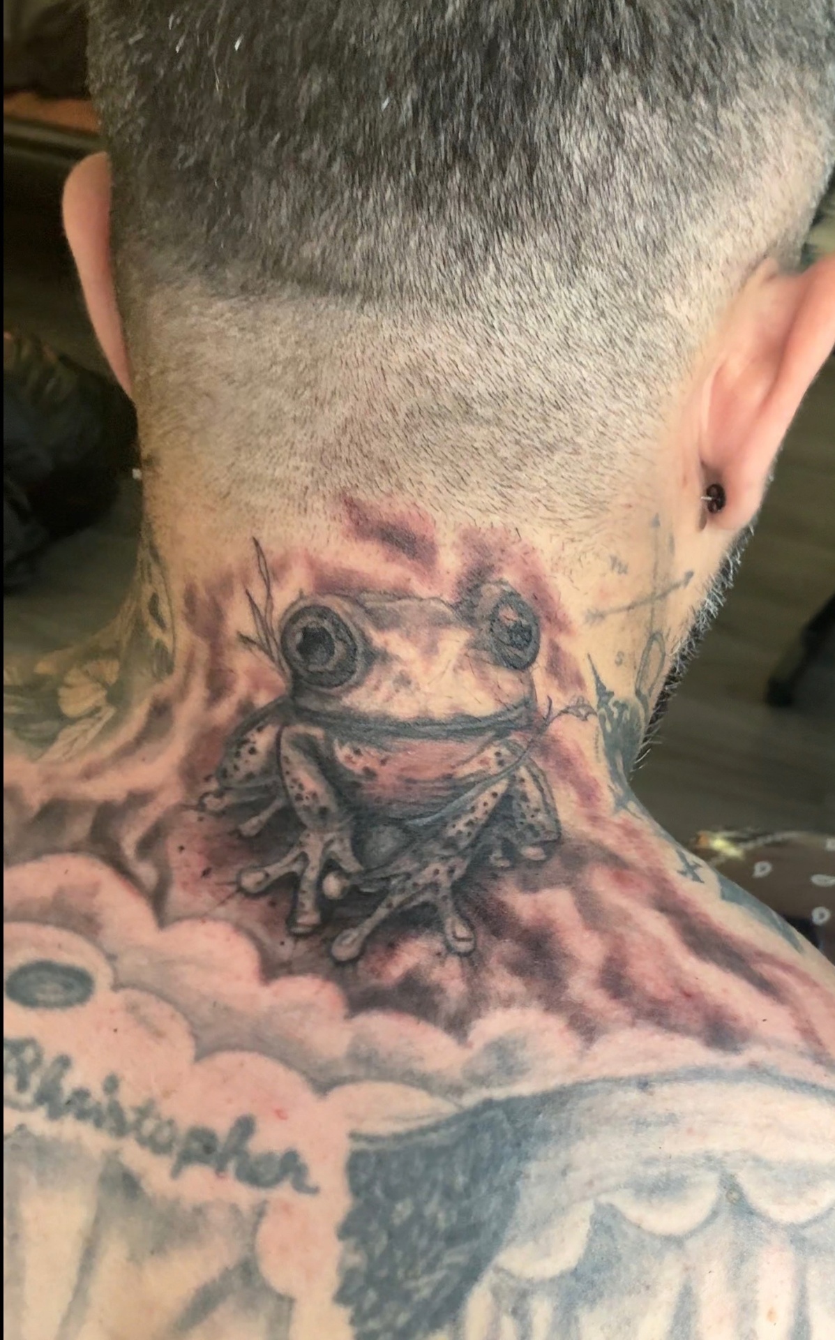 Black and grey frog neck tattoo with smoky background