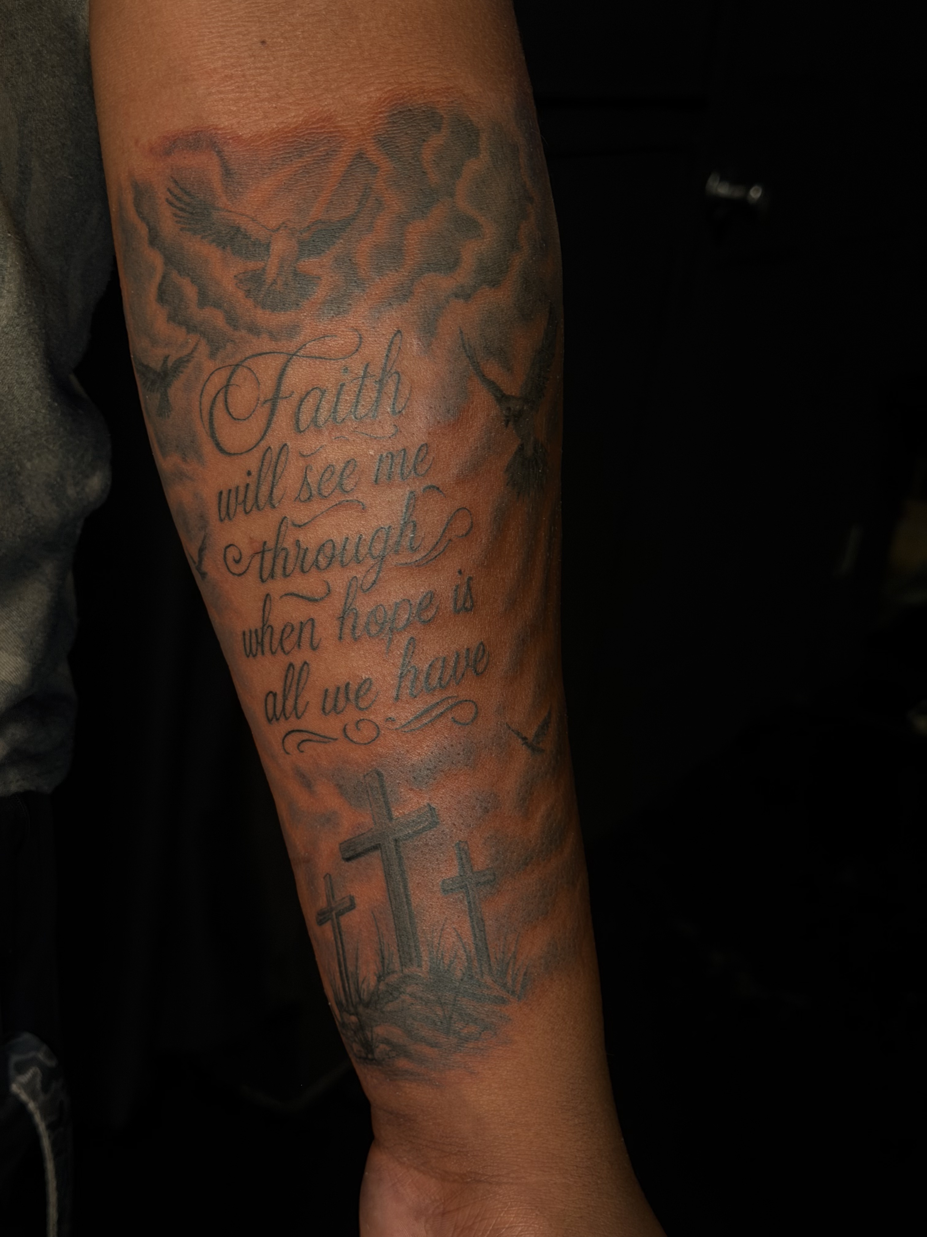 Large black and grey forearm tattoo