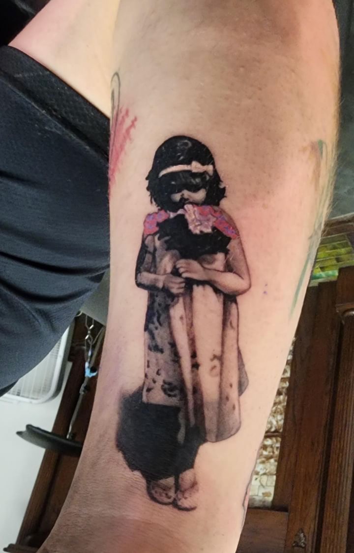 Banksy-style girl with gas mask and flowers tattoo