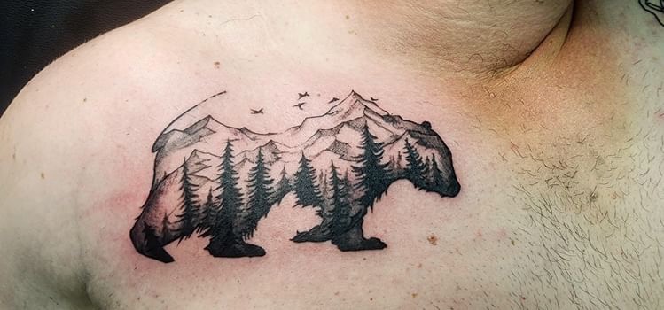 Bear silhouette with mountain and forest landscape chest tattoo