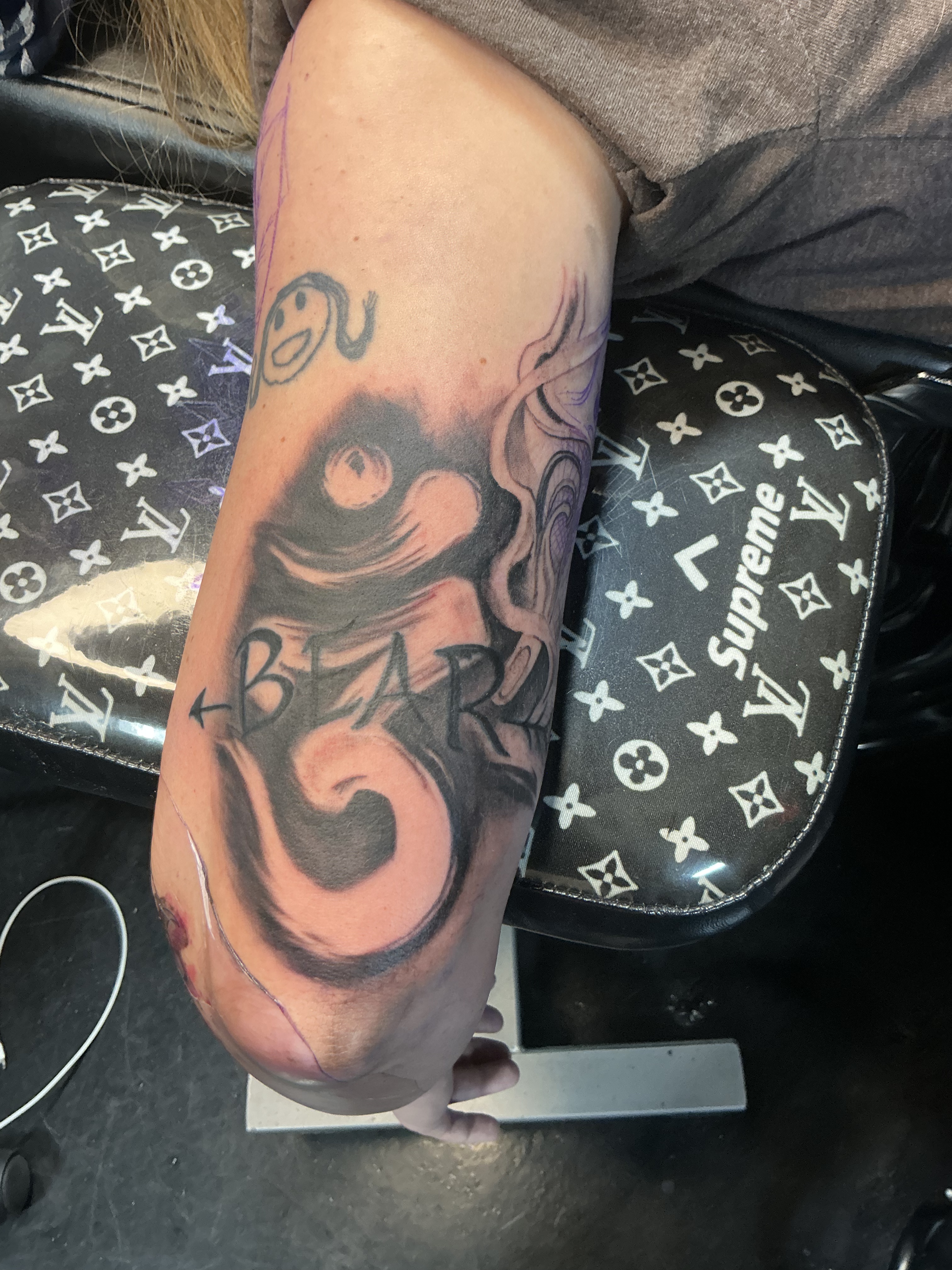 Large red and black illustrative leg tattoo