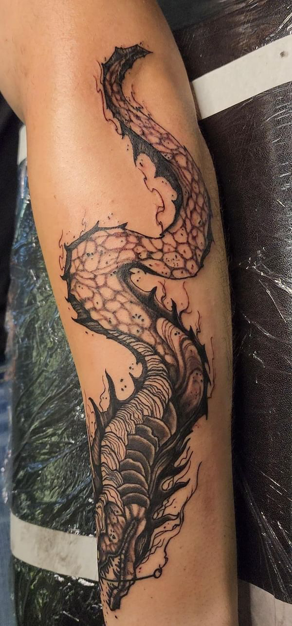 Large black and grey forearm tattoo