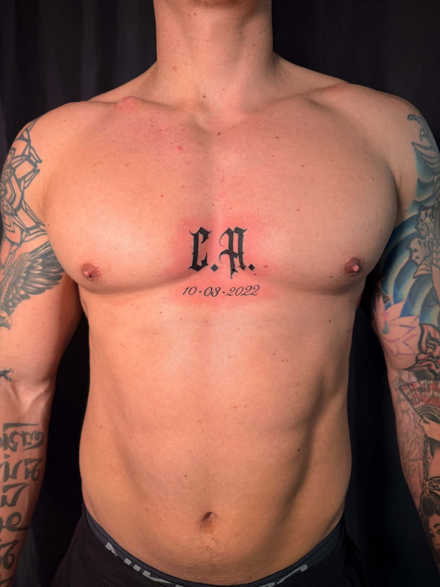 Gothic CA initials with date chest lettering tattoo