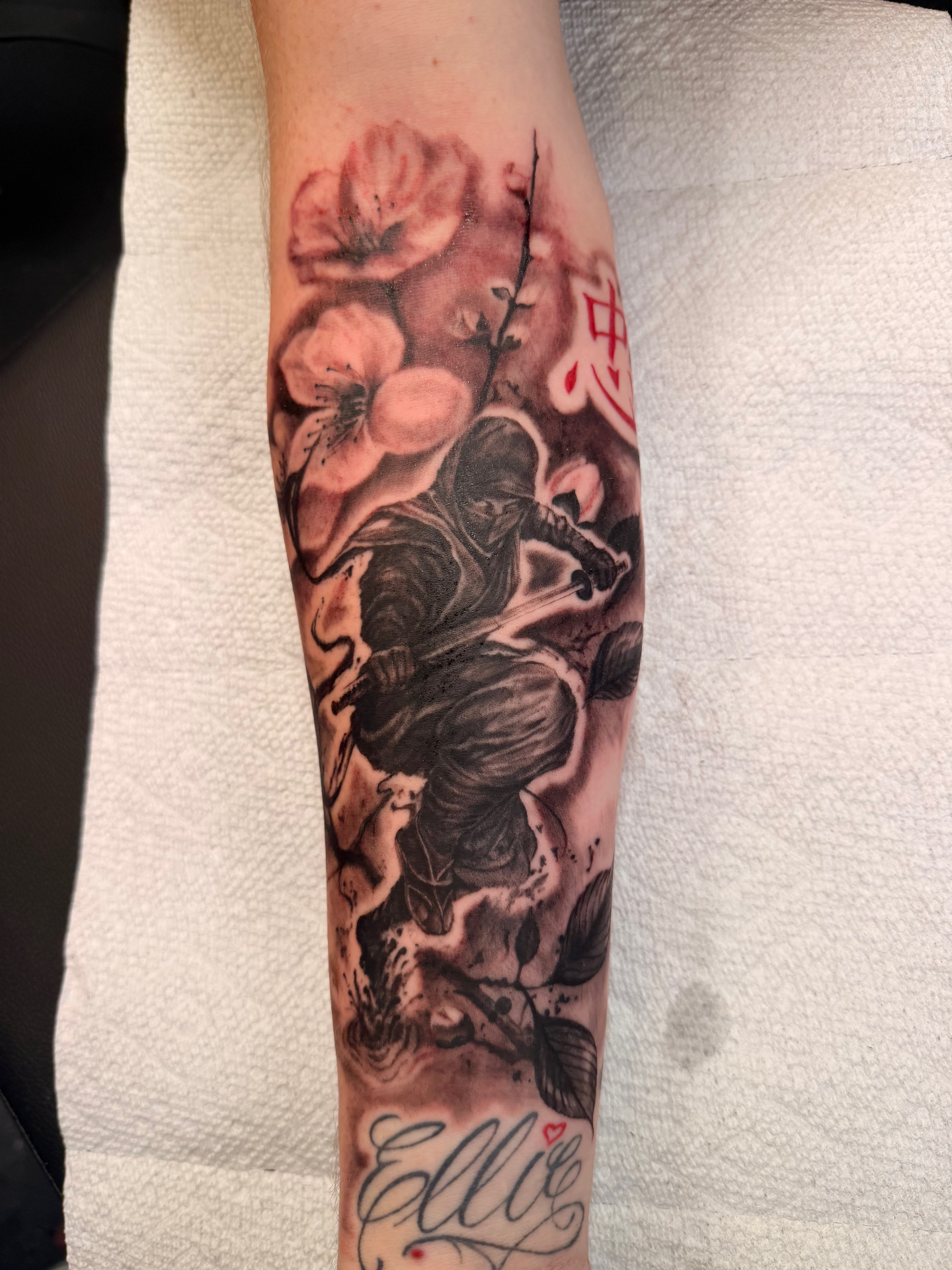 Black and grey samurai with cherry blossoms and red kanji forearm tattoo