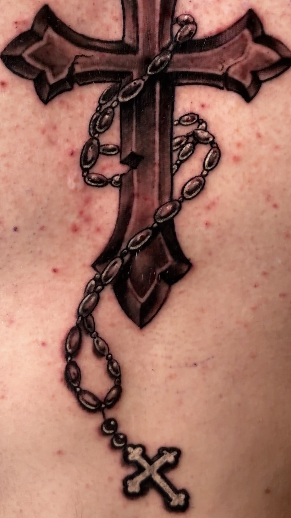 Ornamental cross torso tattoo