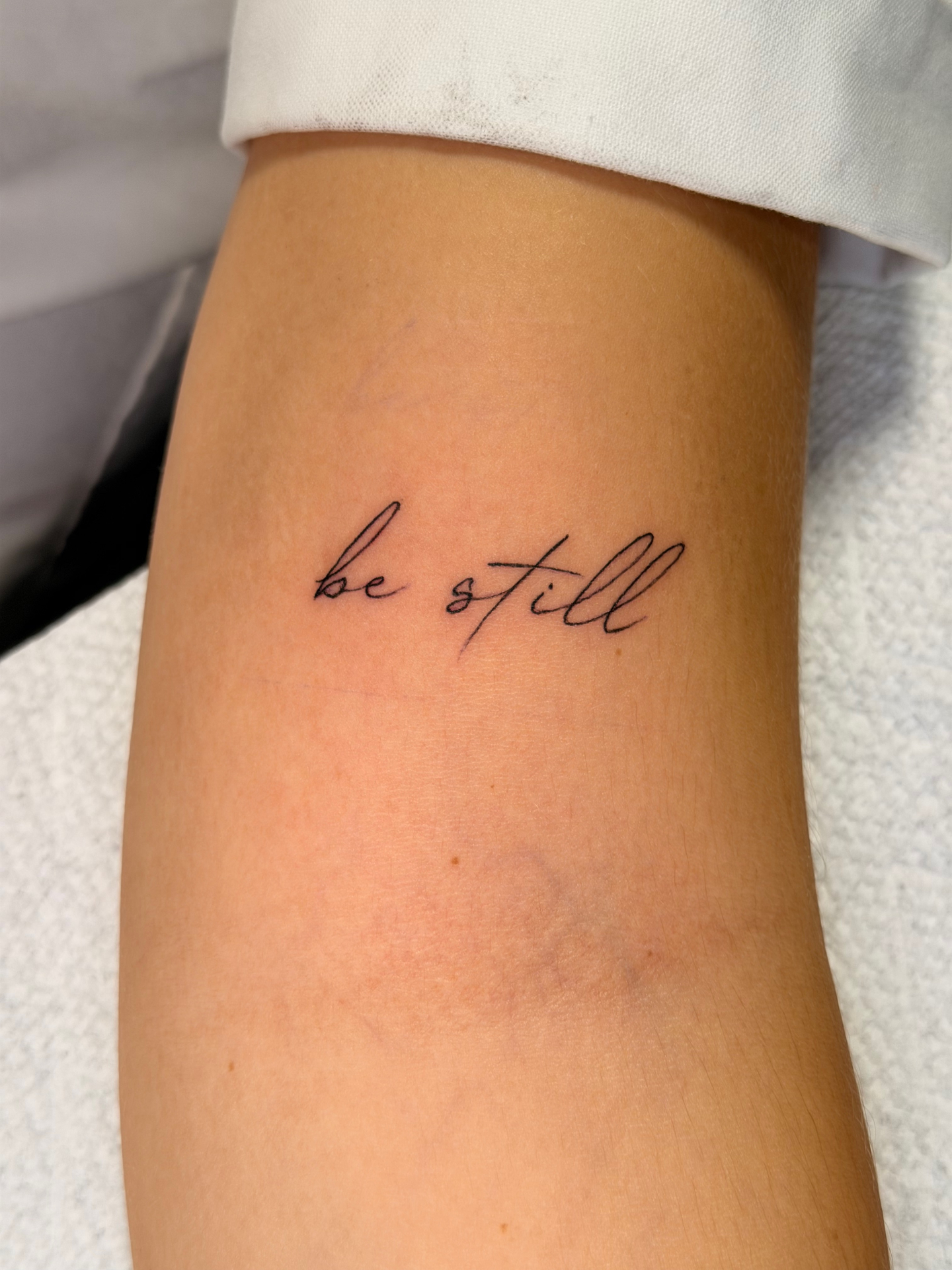 Minimal be still script tattoo