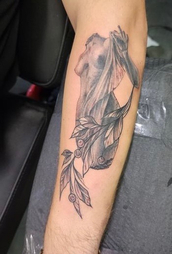 Dark art black and grey figure with botanical elements tattoo
