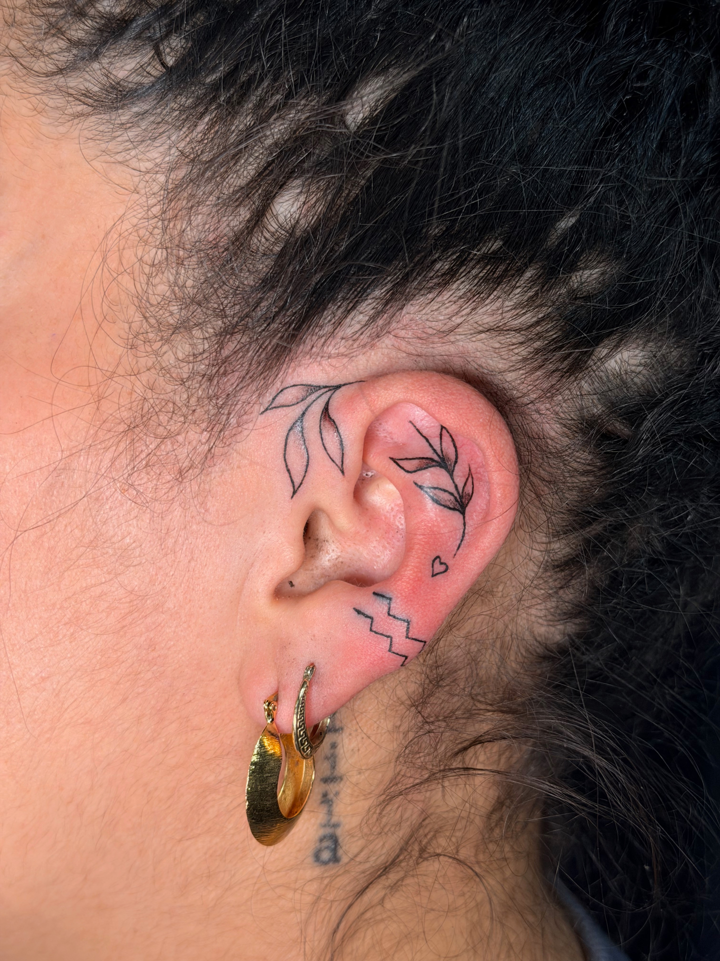 Fine line ear tattoo set with leaves, heart and zigzag accents