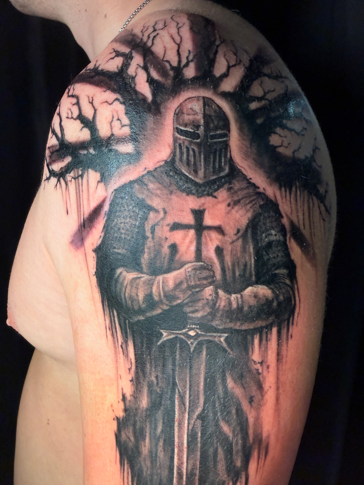 Black and grey knight and cross shoulder tattoo