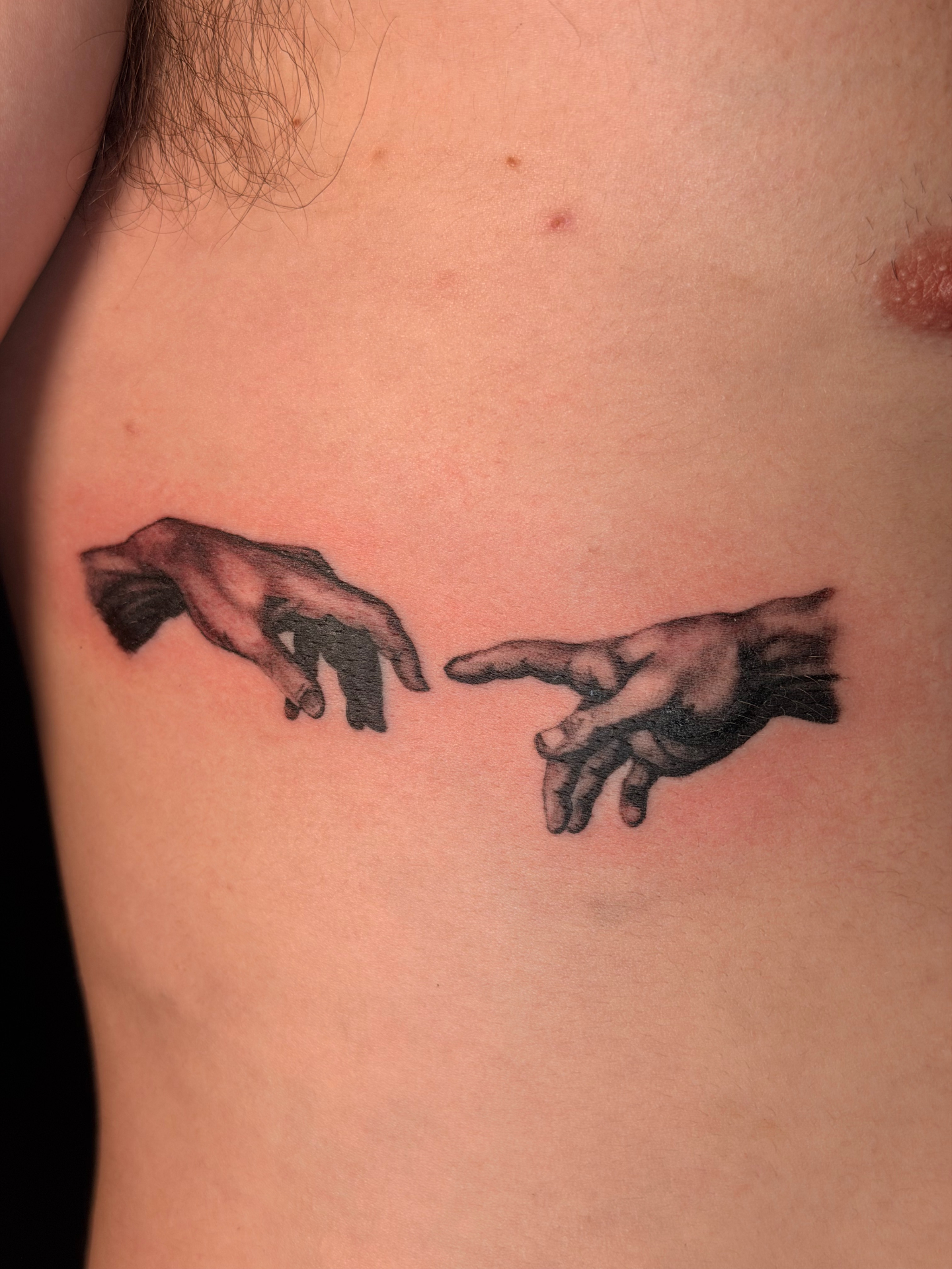 Black and grey creation hands chest tattoo