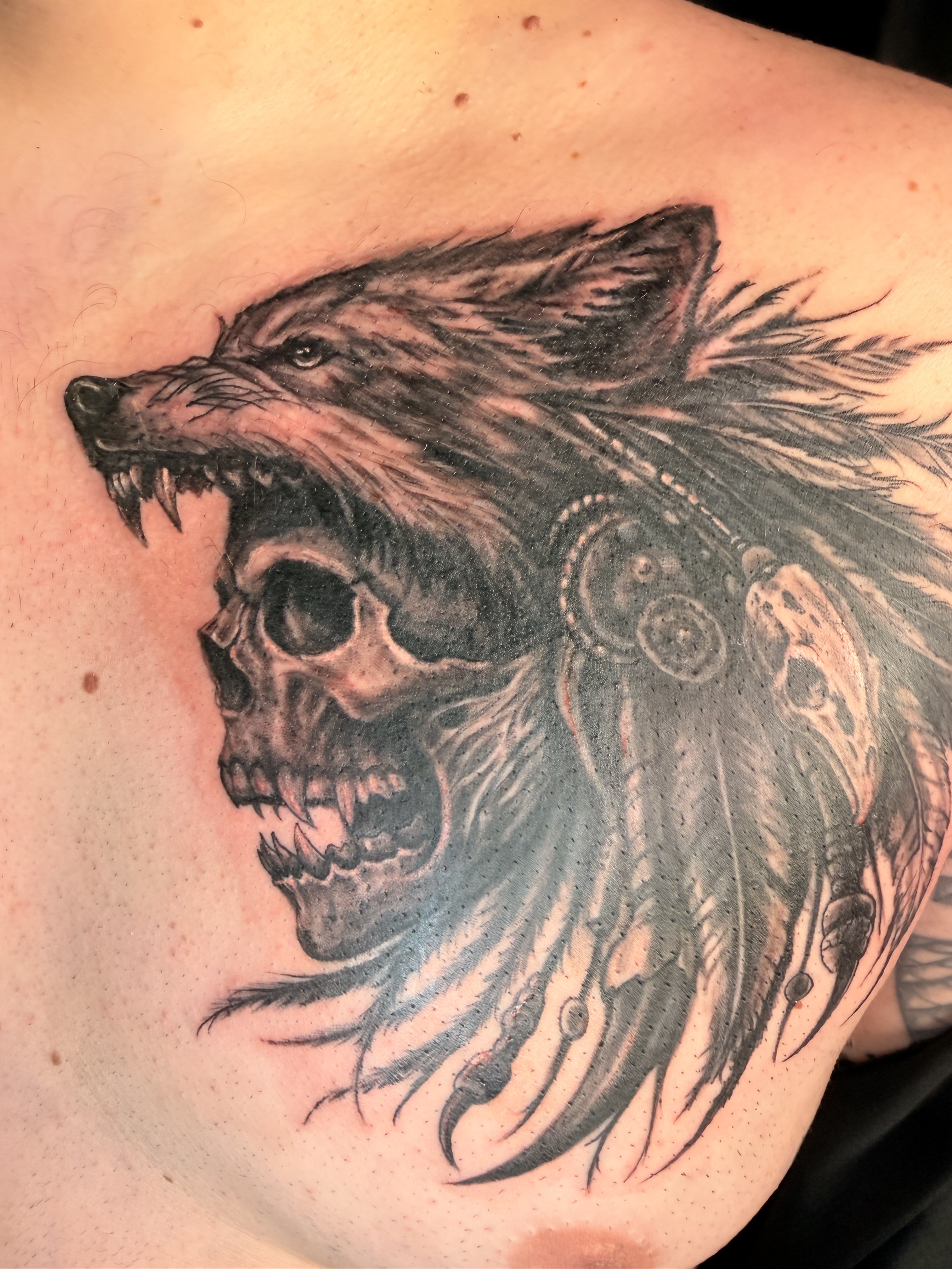 Detailed black and grey wolf and skull dark art tattoo